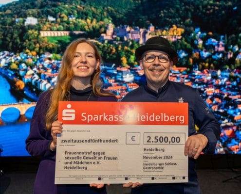 Scheckübergabe von Martin Scharff an Enya Wolf vom Frauennotruf Heidelberg