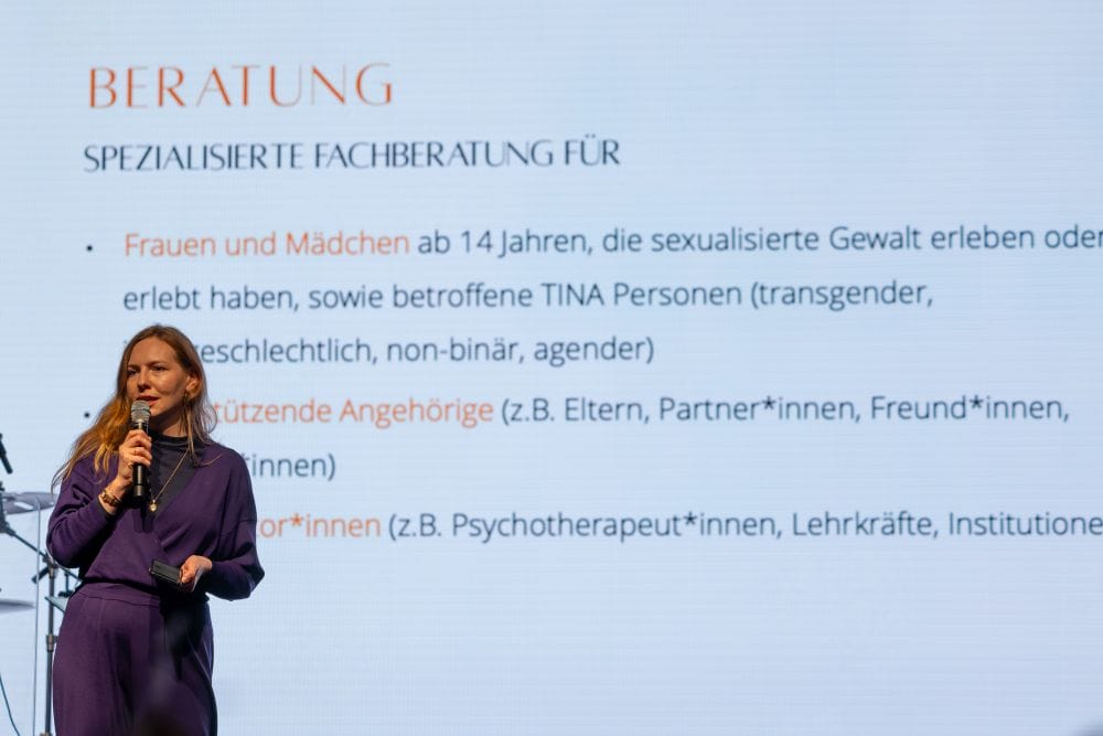 Frau vor einer Powerpoint-Folie zur Beratungsstelle Frauennotruf Heidelberg